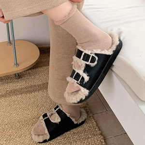 Close-up of winter women's buckled slide sandals with thick faux fur lining and matte finish