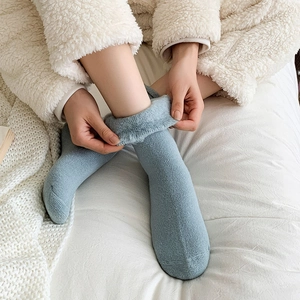 Close-up of light blue thermal socks with thick gray fleece lining and knit texture