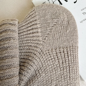 Gros plan de jambières en tricot beige avec texture côtelée douce et détails de qualité