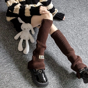 Detail of dark brown cable knit leg warmers with vintage label and ribbed texture