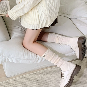 Dettaglio di calze a coste beige con texture a maglia e una piccola etichetta tessuta