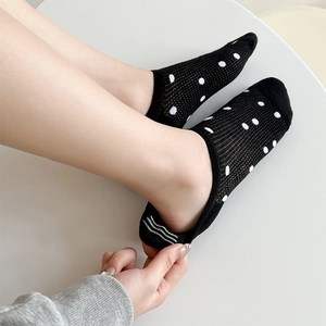 Detail view of black polka dot mesh sock with anti-slip silicone strips on the heel