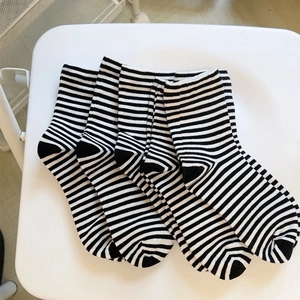 Close-up of four pairs of cotton crew socks with black and white horizontal stripes
