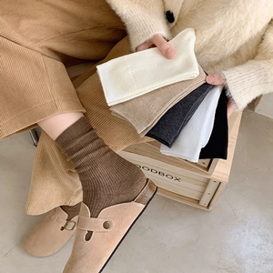 Detailed texture of ribbed cotton crew socks in warm autumn tones and neutral colors