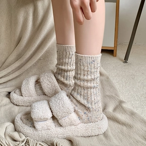 Thick beige wool socks with colorful flecks paired with plush fleece platform sandals