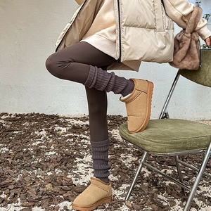 Détail de jambières en tricot avec bottes en daim camel et leggings pour l'hiver