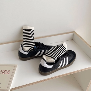Sneaker classiche in pelle nera con strisce bianche e calzini di cotone a righe