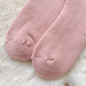 Close-up of the toe seam and knitted texture of warm pink winter floor socks