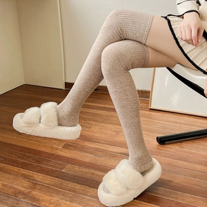 Detailed close-up of ribbed texture on light brown over-the-knee wool socks for winter