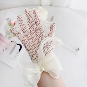 Detailed view of white lace mesh gloves with sheer organza bow and pearl embellishment