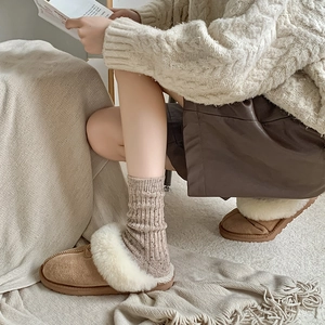 Detailed view of brown suede winter slippers with cozy faux fur trim and thick soles