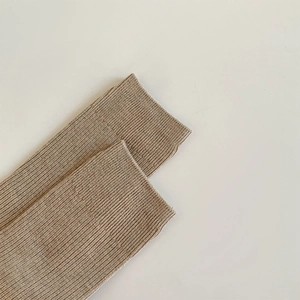 Detailed close-up of ribbed cuffs on beige crew socks showcasing high-elasticity texture