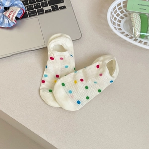 Detail of white mesh socks with colorful polka dots and breathable knit texture
