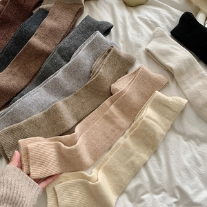Detail of ribbed cuffs on over-the-knee thick knit socks in various earthy colors