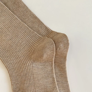 Close-up of light brown ribbed knit socks with reinforced heel and soft texture