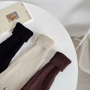 Detailed ribbed knit texture of leg warmers in black, beige, and coffee with R-label