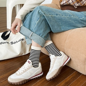 Dettaglio calze a righe in stile college abbinate a sneaker vintage e jeans casual