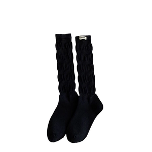 Schwarze Slouch-Socken mit vertikalen Strickrippen und weißem Etikett im Retro-Stil