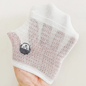 Dettaglio calzini in rete di cotone bianco con trama traspirante e ricamo a panda