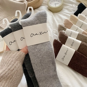 Close-up of assorted earth-tone over-knee socks featuring ribbed cuffs and soft knit texture