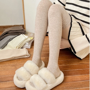 Close-up of thick ribbed knit over-the-knee wool socks in oatmeal beige for winter