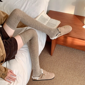 Detail of warm brown ribbed over-the-knee socks with wool texture for winter comfort