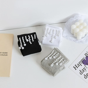 Vue détaillée de chaussettes en maille côtelée avec perles élégantes en noir, blanc et gris