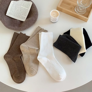 Detailed close-up of ribbed knit crew socks in assorted autumn colors with warm aesthetic