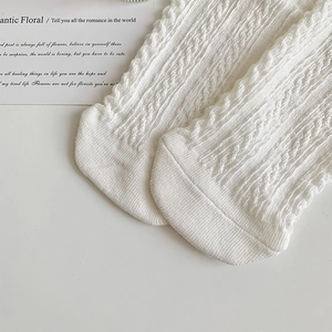 Macro shot of white Lolita knit socks showing intricate wave pattern and soft texture