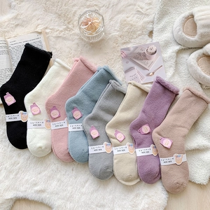 Close-up of assorted thick winter plush socks in soft colors with kiki sox labels