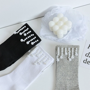 Détail de chaussettes mi-hautes douces avec glands et ornements en perles de résine