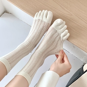 Detail of cream five-toe socks featuring breathable hollow mesh and elastic knit texture