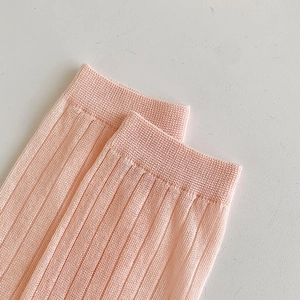 Dettaglio della trama in maglia rosa chiaro e polsini a coste su calze sottili e traspiranti
