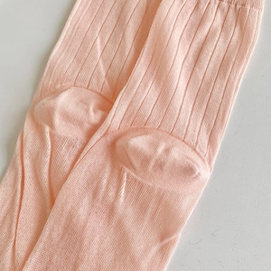 Dettaglio del tessuto in maglia a coste rosa chiaro con texture semitrasparente e trama