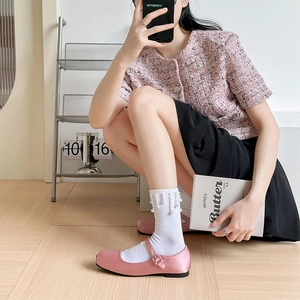 Détail de chaussettes blanches à pampilles de perles avec chaussures Mary Jane roses