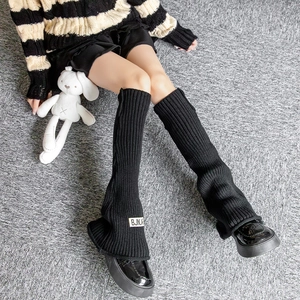 Knitted flared leg warmers for women with ribbed texture and white letter patch detail