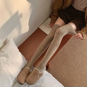 Close-up of thick over-knee knitted socks in earth tones for winter warmth and comfort