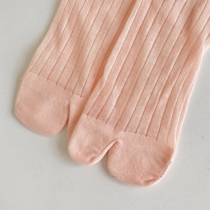 Dettaglio ravvicinato delle calze Tabi rosa a coste in cotone con design a due dita