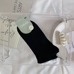 Détail de chaussettes en coton noir avec dentelle blanche et étiquette de marque