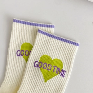 Dettaglio della calza in cotone a coste con cuore verde e scritta GOOD TIME