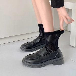 Schwarze Plateau-Loafer für Damen kombiniert mit modischen vertikal gestreiften Socken