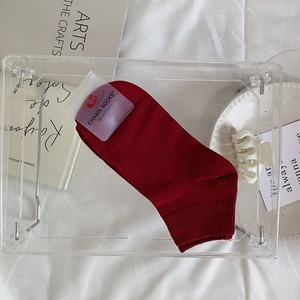 Détail de chaussettes en coton tricoté rouge foncé avec bords côte et emballage