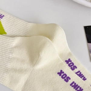 Dettaglio calzino in cotone bianco panna con scritta KIKI SOX viola e grafiche verdi