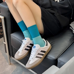 Detail view of stylish blue diagonal pattern mid-calf socks paired with classic sneakers