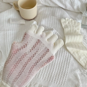 Detail of cream-colored five-finger socks with breathable mesh knit and split-toe design