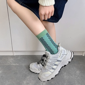 Detailed view of fashionable blue diagonal stripe knit socks worn with white sneakers