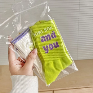 Dettaglio delle calze in maglia colorate in busta di plastica con logo KIKI SOX