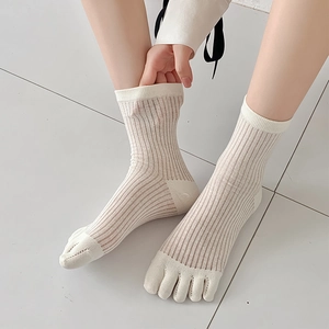 Detail von cremeweißen Fünf-Finger-Socken mit feiner vertikaler Strickstruktur und Zehentrennung