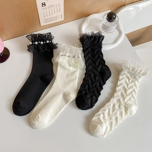 Elegant Japanese lace socks with pearls in black and cream white on a clean table