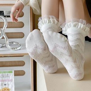 Detailed view of white calf socks with chevron knit pattern and delicate lace ruffles